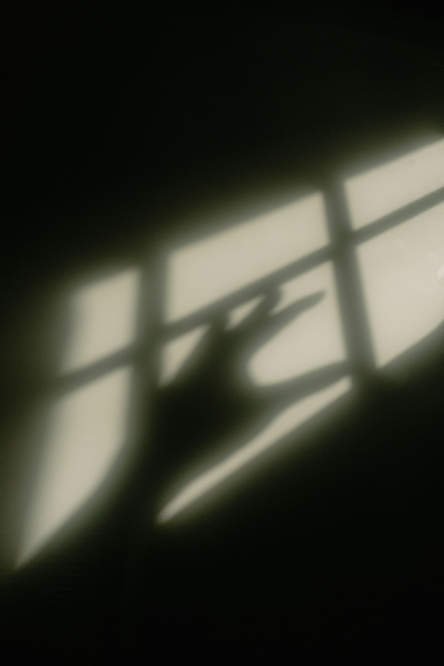 Sombra de una mano en el alféizar de una ventana